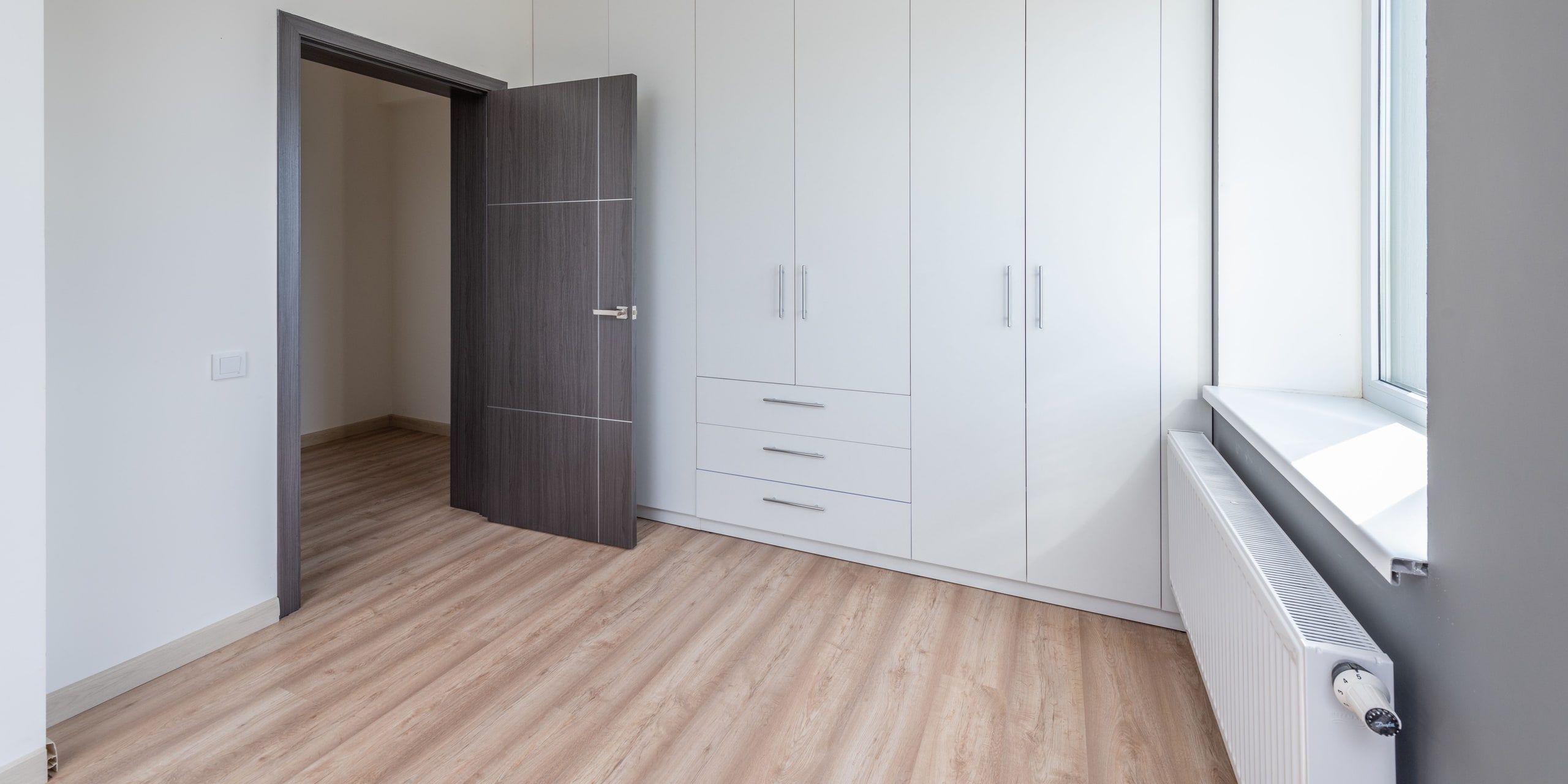 An empty room, cleaned, with light across the floor
