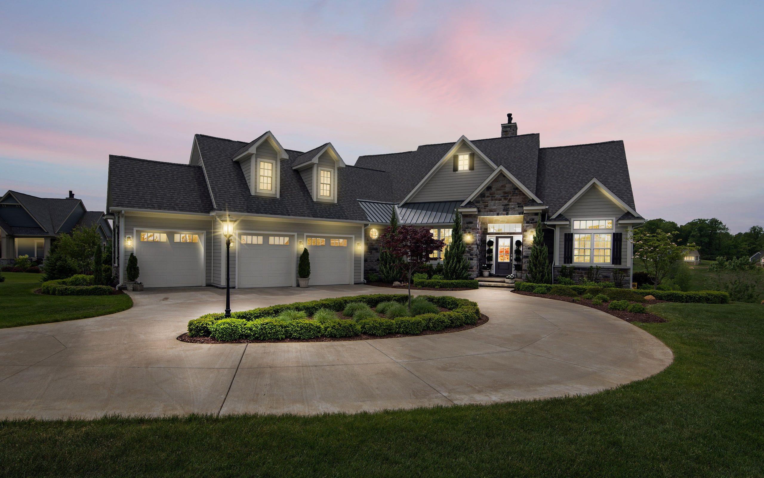 A detached house at dusk with its exterior lighting on