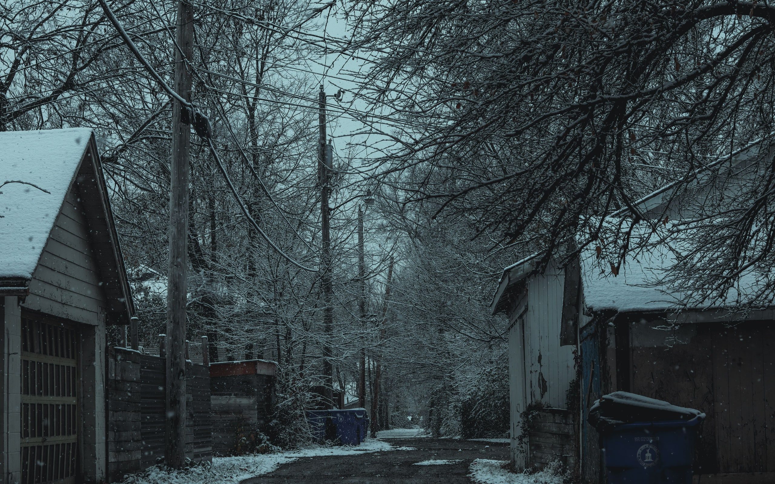A house and driveway under snow in the early evening
