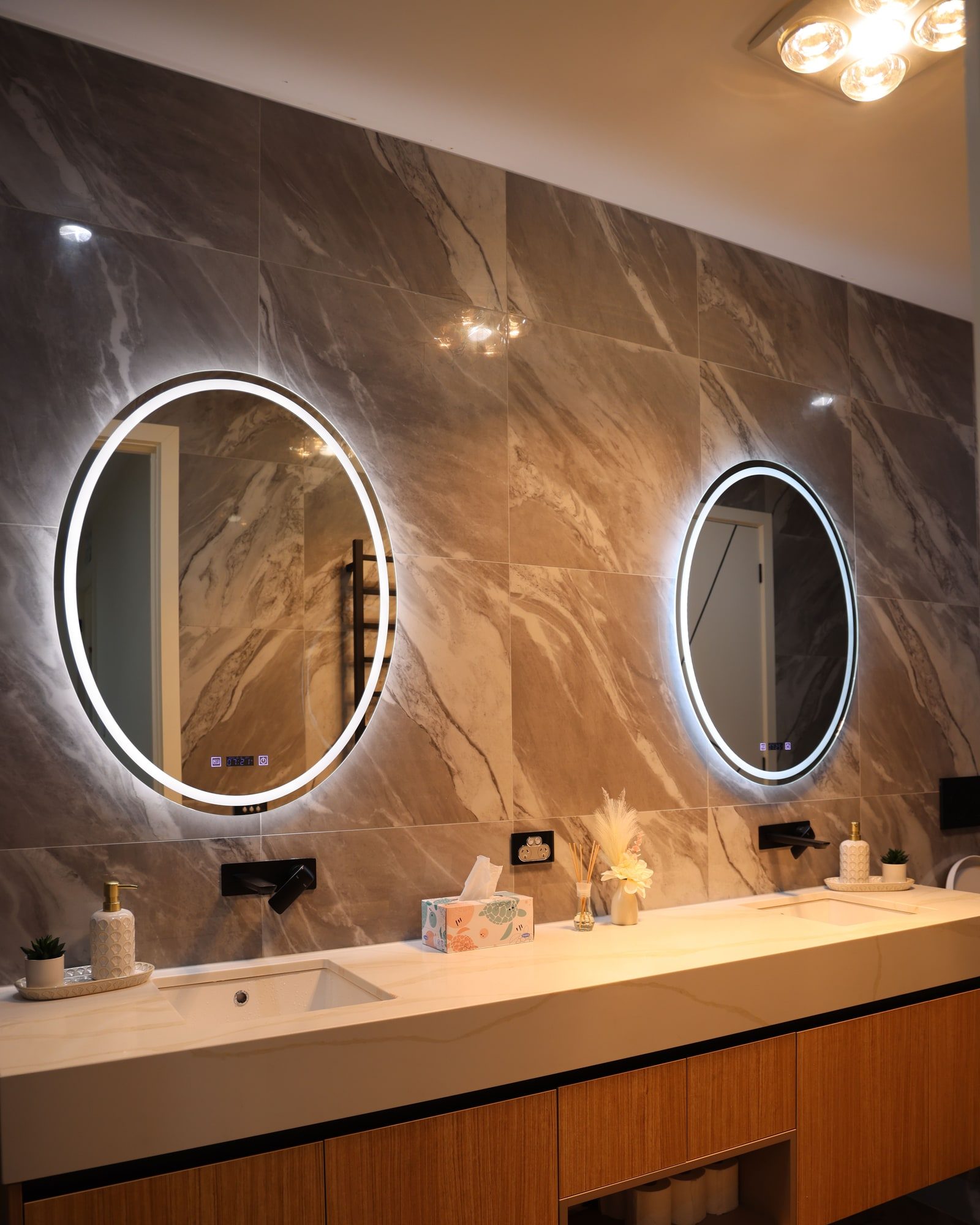 A bathroom vanity with stone counter and mirror