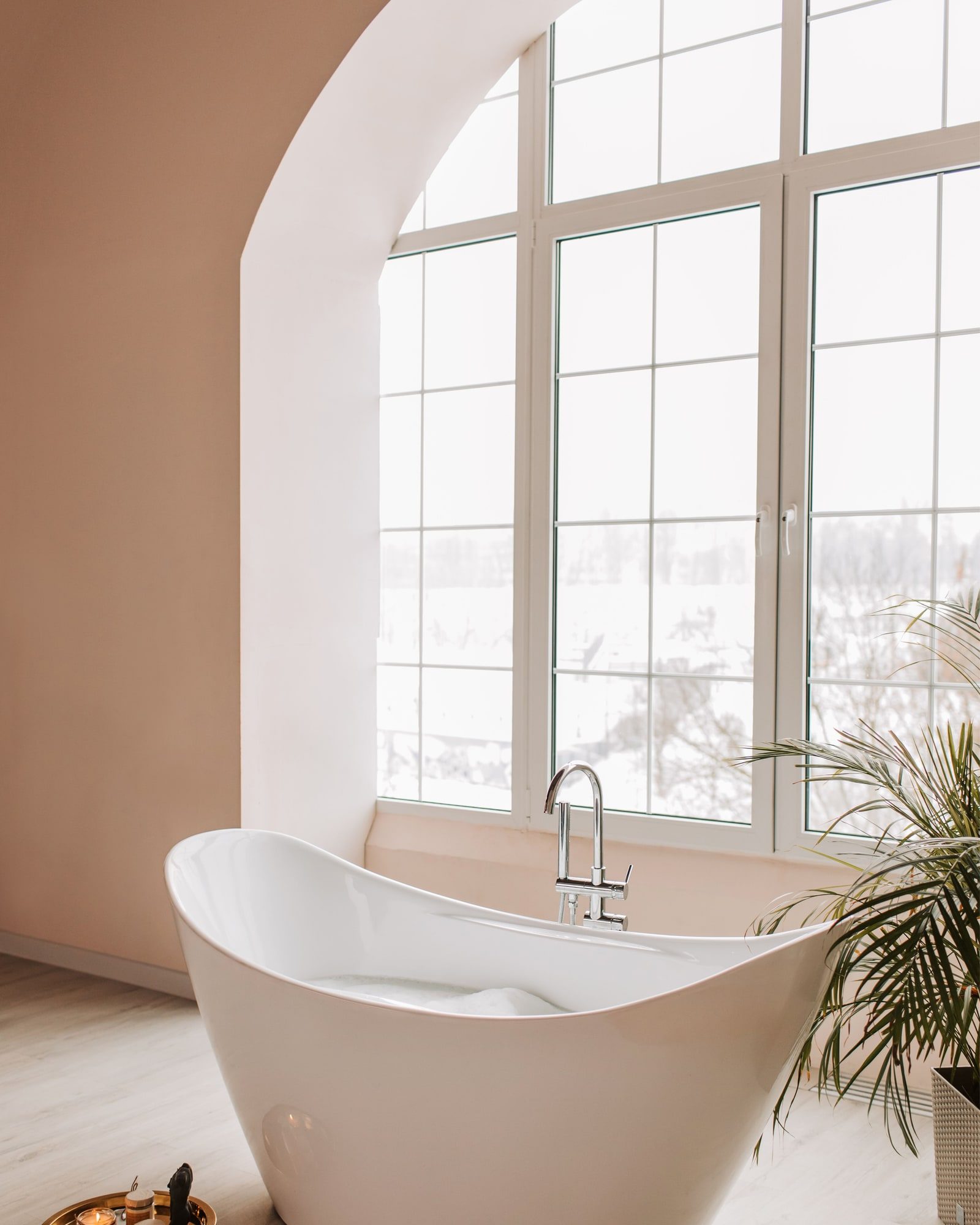 A freestanding bath beside a window