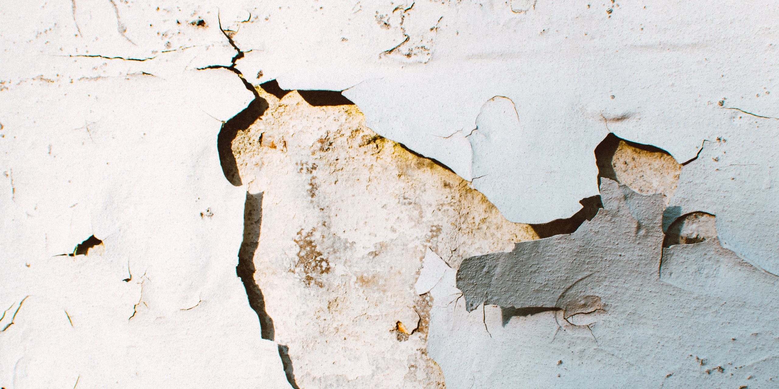 Cracked plaster and peeling paint on a wall