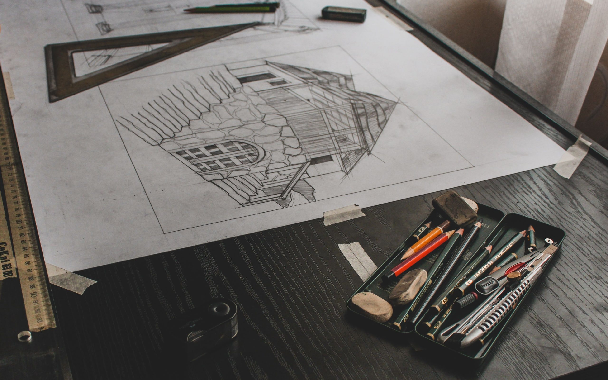 An architectural sketch and drafting tools on a desk