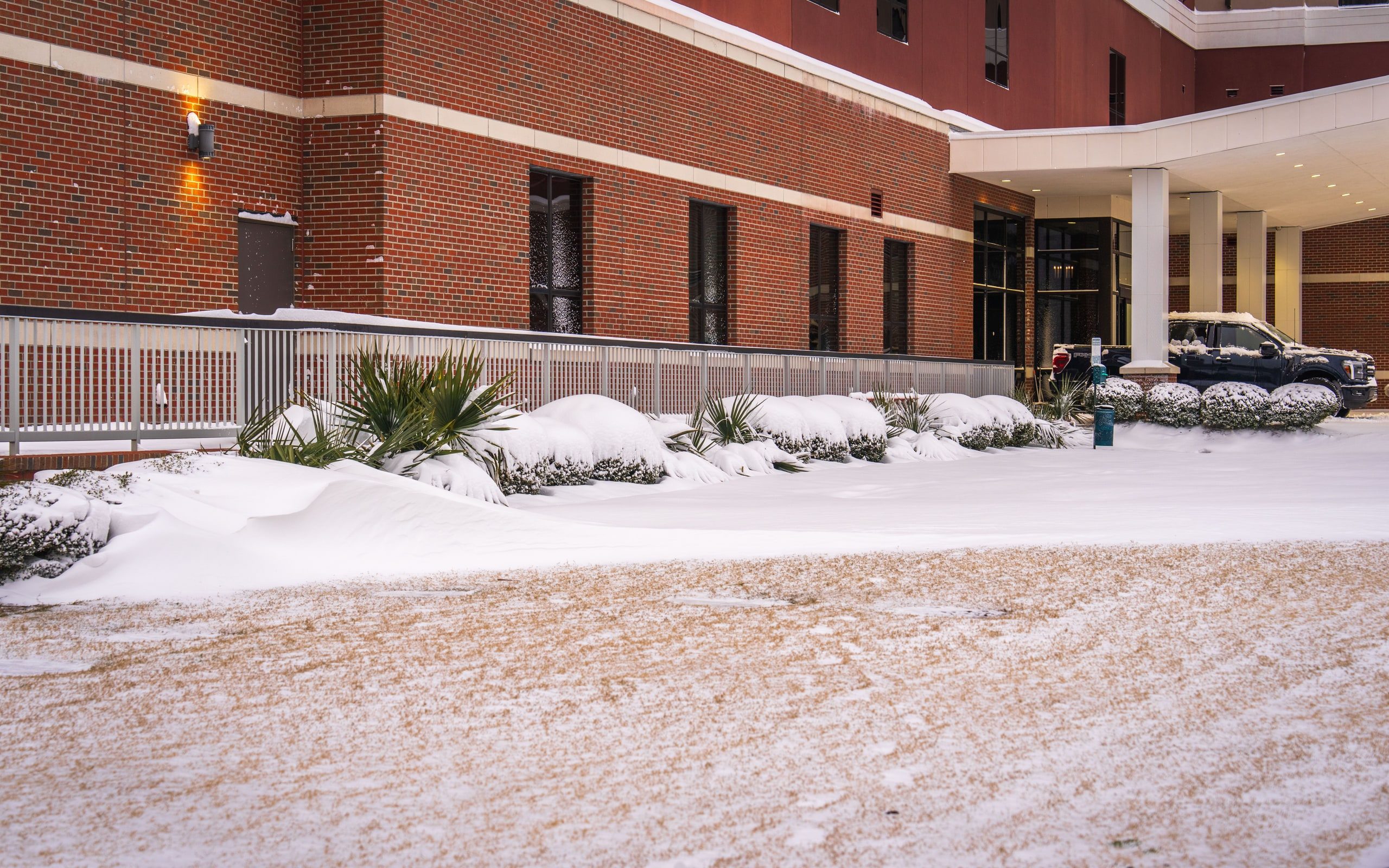 A commercial building entrance in winter, its approach cleared and salted